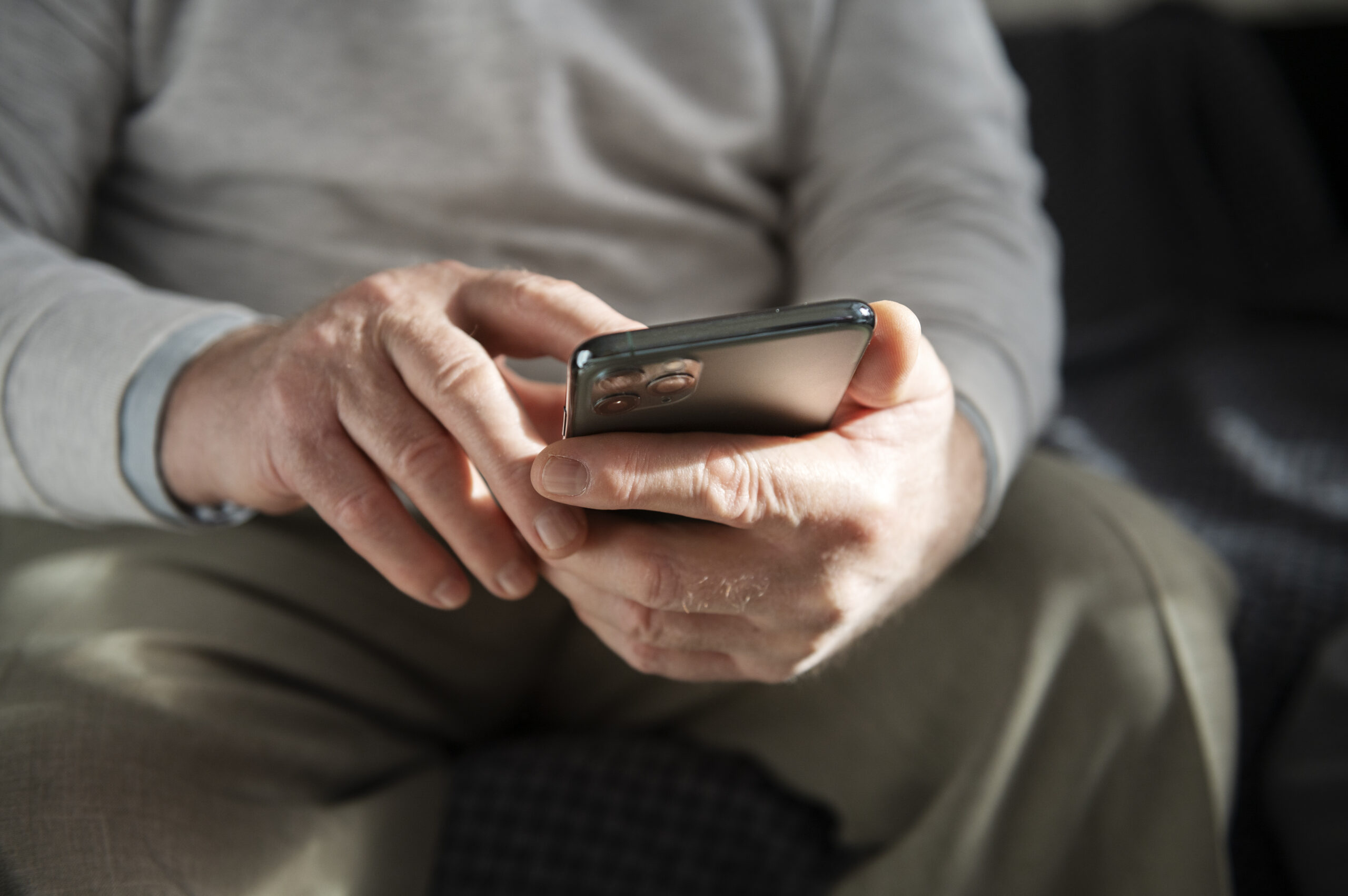 Elderly person using smartphone at home