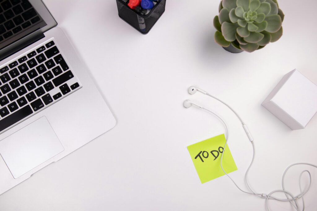 Workspace with laptop, earphones, and a sticky note labeled “To Do”