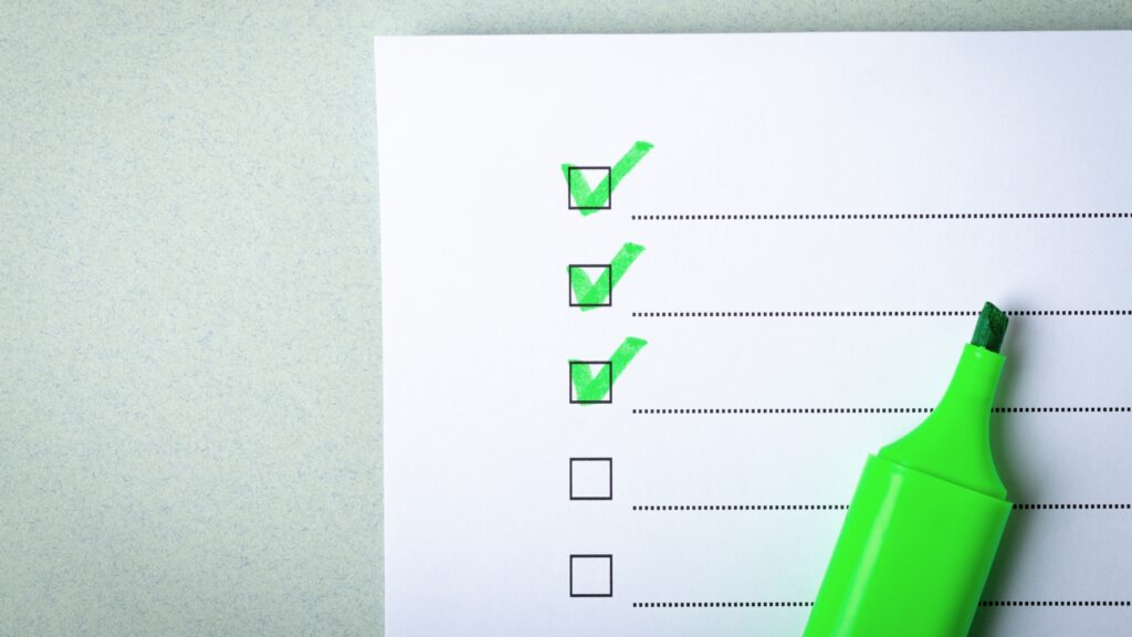 Close-up of a checklist with green check marks, symbolizing safe online practices and awareness of digital risks.
