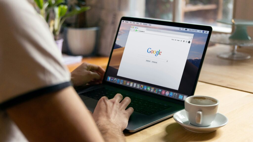 Person typing on a laptop with the Google homepage open, representing checking one’s digital presence.