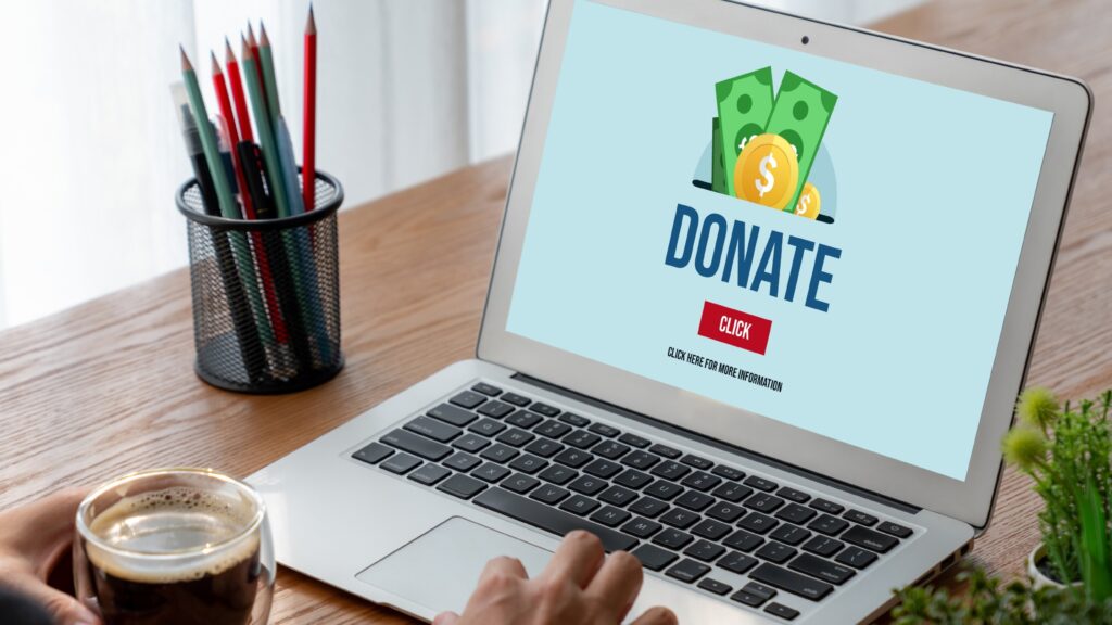Person viewing a donation page on a laptop, symbolizing the importance of checking a charity’s legitimacy before giving online.