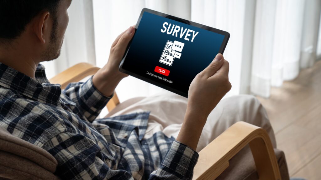 A person holding a tablet with an online survey prompt, symbolizing how free digital services often gather personal data behind the scenes.