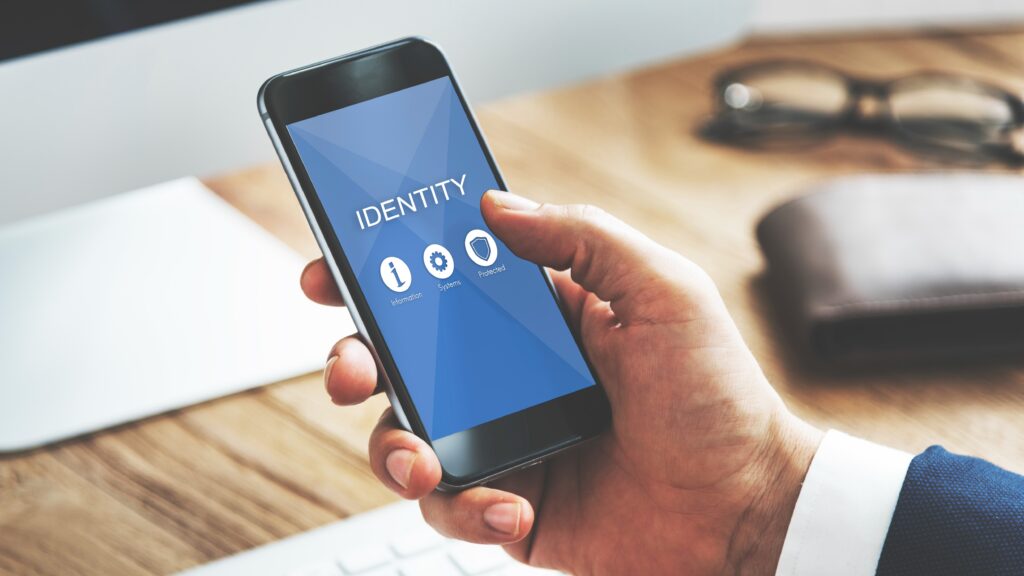 Person holding a smartphone with the word “Identity” on the screen, symbolizing digital identity protection and online privacy.