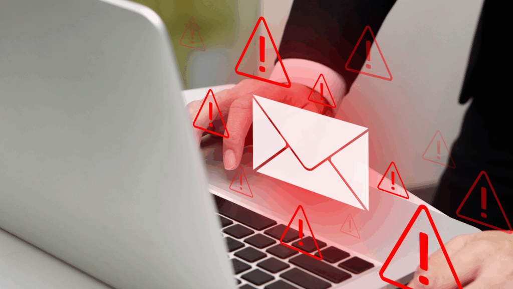 Person using a laptop with warning icons and email alert symbol indicating phishing risk