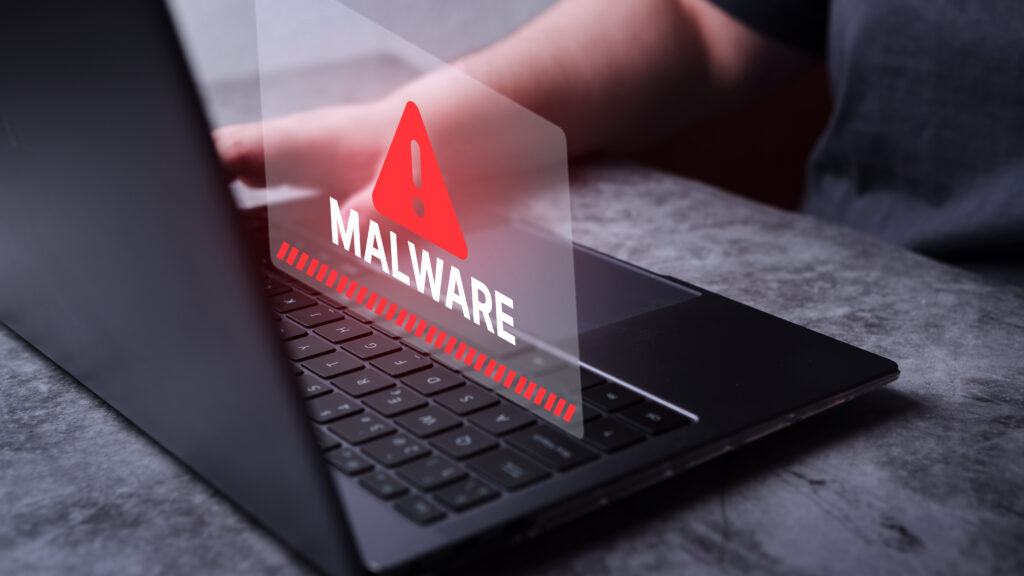 Warning sign showing malware risk on laptop caused by malicious browser extensions
