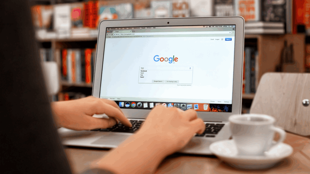 Person using a laptop to search on Google homepage