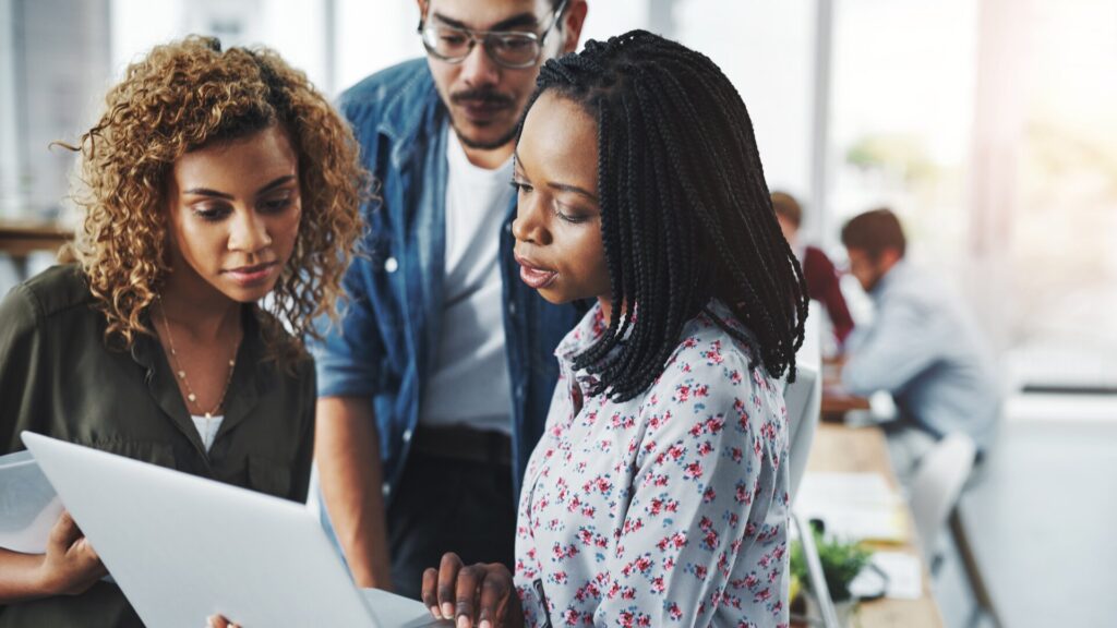 Employees looking at documents together, showing how a data breach can affect staff
