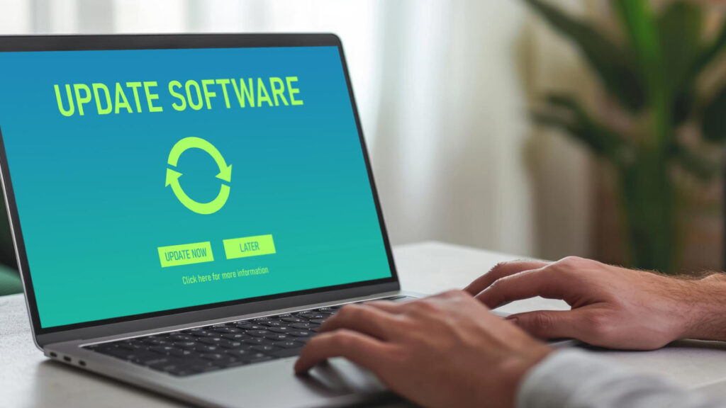 Person updating software on a laptop, a simple step Microsoft recommends to help reduce the risk of malware from fake AI-recommended websites.