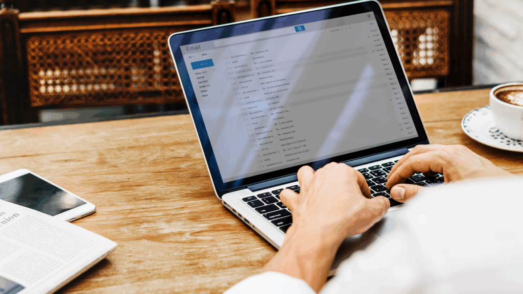 Person using a laptop to check email, with inbox open on screen