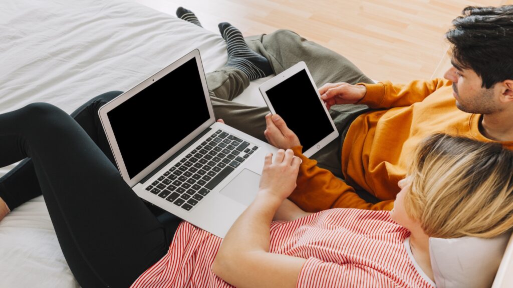 Family using laptop and tablet together at home, showing shared access to online accounts and password security risks.