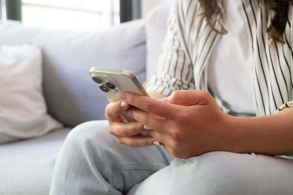 Person checking a message on a smartphone after the LastPass data breach, with guidance on spotting phishing attempts.
