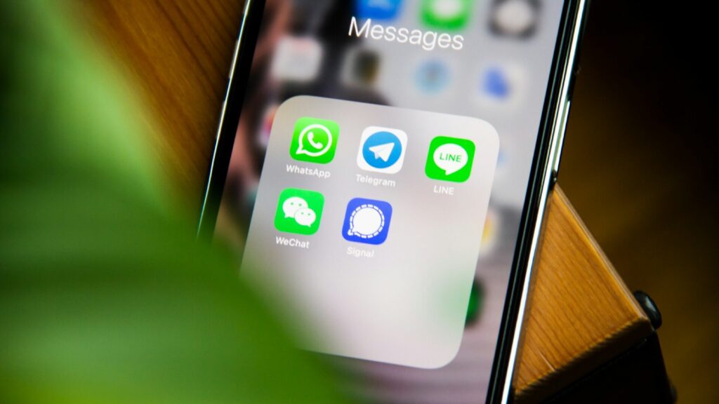 Smartphone displaying WhatsApp and other messaging apps, illustrating safer communication and privacy settings.