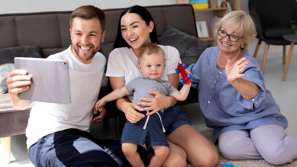 Family video call with an older woman and young parents, illustrating how families can verify urgent calls and protect loved ones from AI imposter scams.