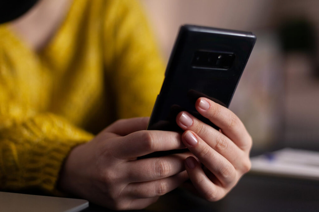 Person using a smartphone to review privacy and security settings before joining a virtual call.