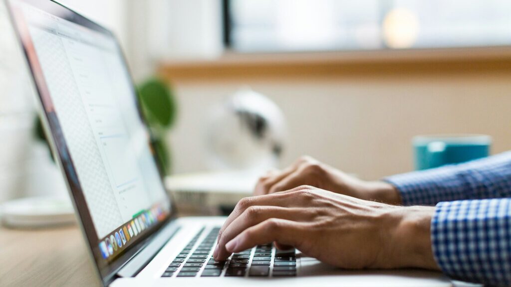 Person using a laptop to review account security after the Moody Bible Institute data breach.
